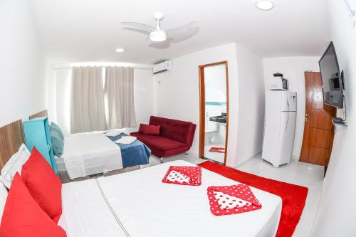 a room with a bed and a red chair at Pousada Central de Arraial in Arraial do Cabo