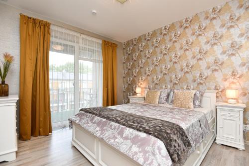 a bedroom with a large bed and a window at Apartamentai Šviesa in Palanga