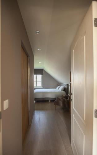 a bedroom with a bed and a hallway with a door at Vakantiewoning Nr63 in Brakel