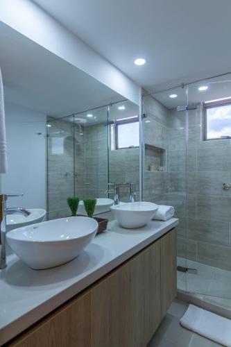 a bathroom with two sinks and a shower at Alcazar de Oviedo by EE Hoteles in Medellín
