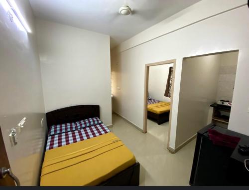 Habitación pequeña con cama y espejo. en Orchid Home en Bangalore