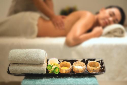 a woman laying in bed with a tray of food at Radisson Cartagena Ocean Pavillion Hotel in Cartagena de Indias