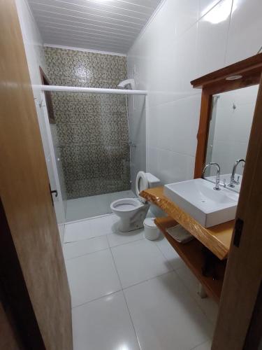 a bathroom with a shower and a toilet and a sink at Residencial Franzen in Canela