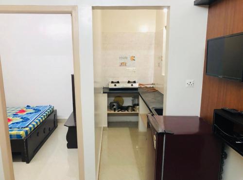 a small kitchen with a stove in a room at Orchid Home in Bangalore