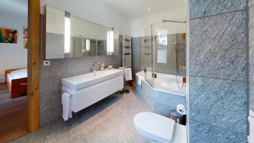 La salle de bains est pourvue d'une baignoire, d'un lavabo et de toilettes. dans l'établissement Chalavus, à Saint-Moritz