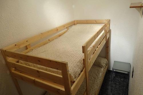 Ce lit superposé en bois se trouve dans un dortoir doté d'une chaise. dans l'établissement Apartamento rural en Los Pirineos, à Guardiola de Berguedà