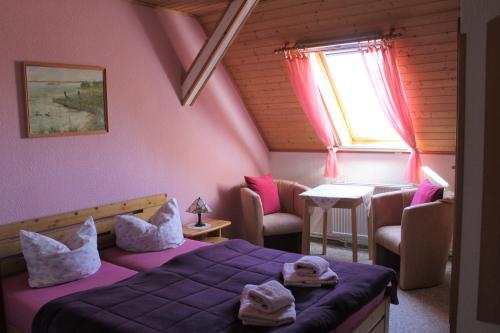 a bedroom with a bed and a table and a window at Pension Jägerrast in Boek