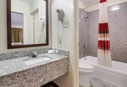 a bathroom with a sink and a toilet and a tub at Red Roof Inn & Suites Commerce - Athens in Commerce