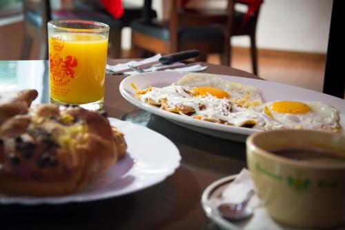a table with two plates of eggs and a cup of coffee at Hotel El Senador in Mexico City