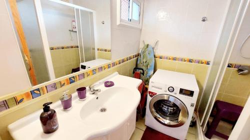 a bathroom with a sink and a washing machine at FIRST LINE Los Geranios Ocean View Apartment Air Conditioned 50 m from La Pinta beach in Adeje