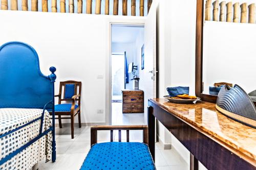 een kamer met een bed en een tafel met blauwe stoelen bij Casa Nenè in Otranto