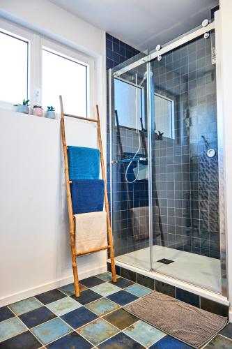 La salle de bains est pourvue d'une douche en verre et d'une chaise. dans l'établissement CHARNER centre gare 2 chambres 100m2 parking, à Saint-Brieuc
