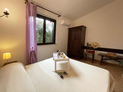 Un dormitorio con una cama blanca y una mesa. en Ada en Monte Nai