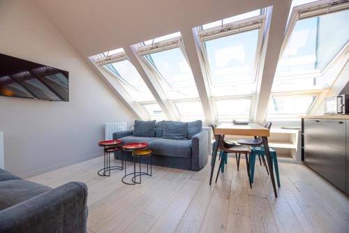 un soggiorno con divano e tavolo con sgabelli di Résidence du Louvre a Parigi