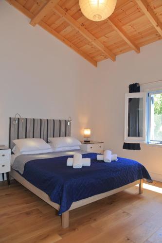 a bedroom with a large bed with towels on it at BLUE SKY COTTAGE, Kanouli beach in Halikounas