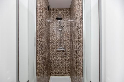 ein Bad mit einer Dusche mit braunen Fliesen in der Unterkunft Casa D'Ouro Apartment in Porto