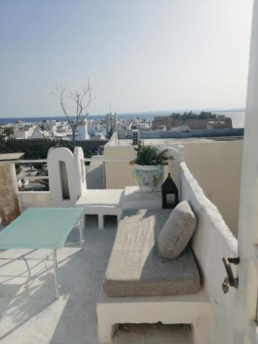 a balcony with a bench and a table and chairs at le mirador in Hammamet