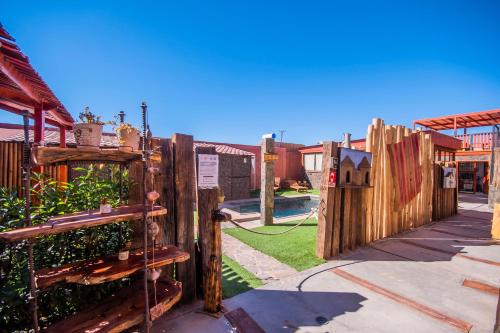 a wooden fence next to a yard with a house at Hotel Casa Algarrobo in San Pedro de Atacama
