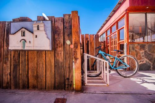 a blue bike parked next to a wooden fence at Hotel Casa Algarrobo in San Pedro de Atacama
