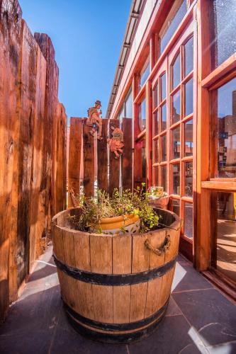a wooden barrel with plants in it next to a building at Hotel Casa Algarrobo in San Pedro de Atacama