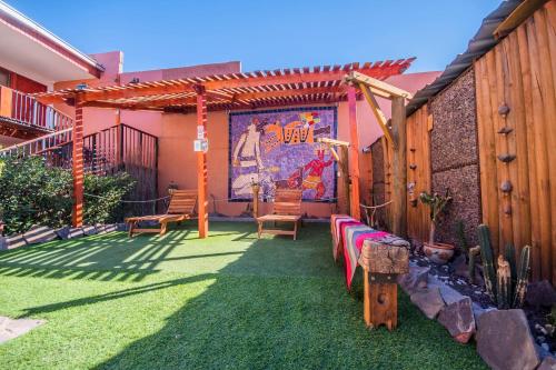 a patio with chairs and a mural on the wall at Hotel Casa Algarrobo in San Pedro de Atacama