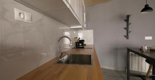 a kitchen with a stainless steel sink and wooden floor at Estudio Morella in Morella