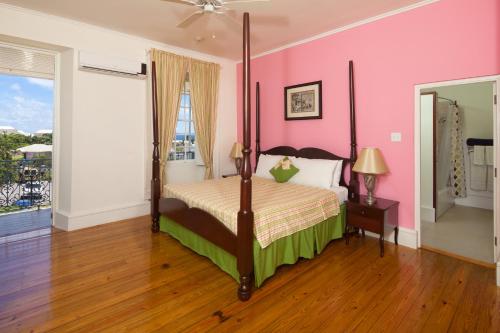 a bedroom with a bed and a pink wall at Savannah Beach Club Hotel & Spa in Bridgetown