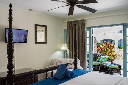 a bedroom with a bed and a living room at Savannah Beach Club Hotel & Spa in Bridgetown