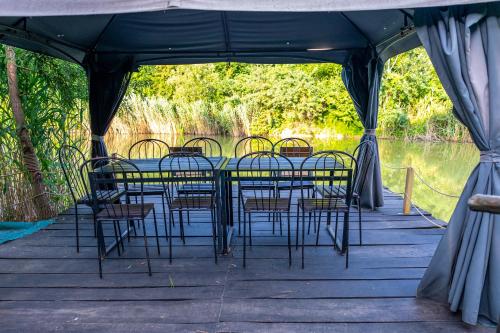 a table and chairs in a tent on a dock at Pensiunea VisAventura in Vişan