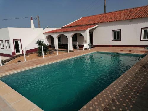 a swimming pool in front of a house at Quinta Catarina in Albufeira
