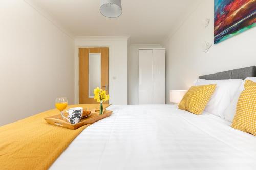a bedroom with a large white bed with a tray with flowers on it at KVM - Peacock Apartment close to town by KVM Stays in Peterborough