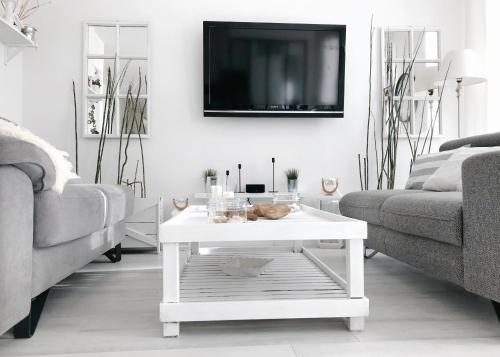 sala de estar con mesa de centro blanca y TV en Gare - Les Champs - 1 SDB privative - parking gratuit en Saint-Brieuc