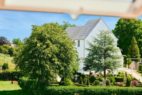 a white house with trees in front of it at Gormsgade lejlighed in Jelling
