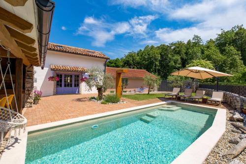 een zwembad voor een huis met een parasol bij Oasis Natura - Villa Antonio in Jurdani