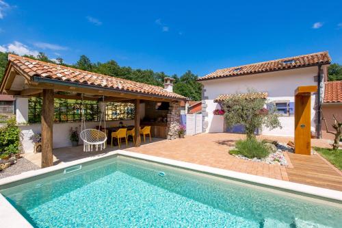 een achtertuin met een zwembad en een huis bij Oasis Natura - Villa Antonio in Jurdani