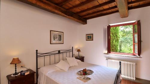 um quarto com uma cama e uma janela em Raffaello em Gaiole in Chianti