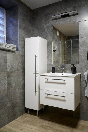 a white bathroom with a sink and a mirror at OSTOJA SŁAWIANOWO nad jeziorem in Sławianowo