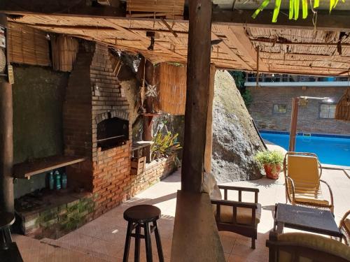 un patio con un horno de ladrillo junto a la piscina en Pousada do Holandes, en Itaipuaçu