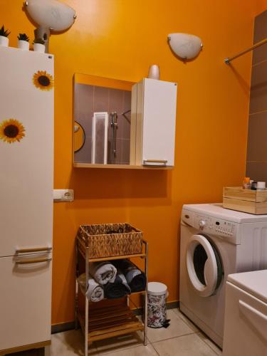 a laundry room with a washing machine and a washer at Libau Baden apartamenti in Liepāja