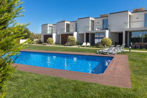 a villa with a swimming pool in front of a house at Blue Villa H - Sagres - 10 min walk to the beach in Sagres