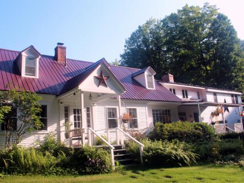 ein weißes Haus mit einem lila Dach in der Unterkunft Buttonwood Inn on Mount Surprise in North Conway