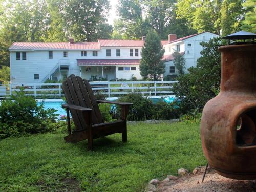 a chair sitting in the grass in front of a house at Buttonwood Inn on Mount Surprise in North Conway