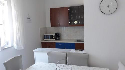 a kitchen with a table and a clock on the wall at Apartments Roviš in Tar