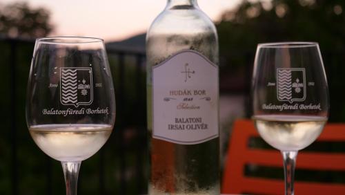 two wine glasses sitting next to a bottle of wine at Anna Villa Füred Boutique Rooms in Balatonfüred