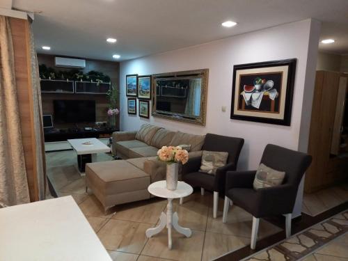 a living room with a couch and chairs and a table at Guest House Maja in Novi Sad