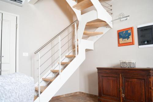 a white staircase in a room with a wooden cabinet at PODERE IL QUADRO in Lamporecchio