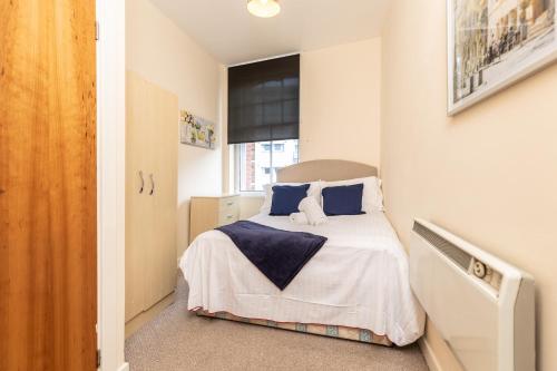 a small bedroom with a bed with blue pillows at Oakstays Central Gem in Newcastle upon Tyne