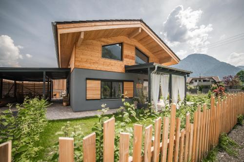 a wooden house with a fence in front of it at Haus Wildmoos in Sankt Martin bei Lofer