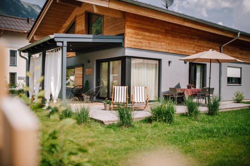 a house with a patio with a table and an umbrella at Haus Wildmoos in Sankt Martin bei Lofer