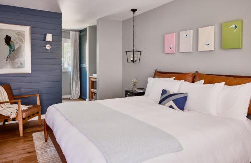 1 dormitorio con 1 cama blanca grande y paredes azules en Journey East Hampton en East Hampton
